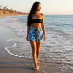 beautiful woman with long black hair walking along the waves in Malibu beach wearing colorful tie-dye shorts with a drawstring