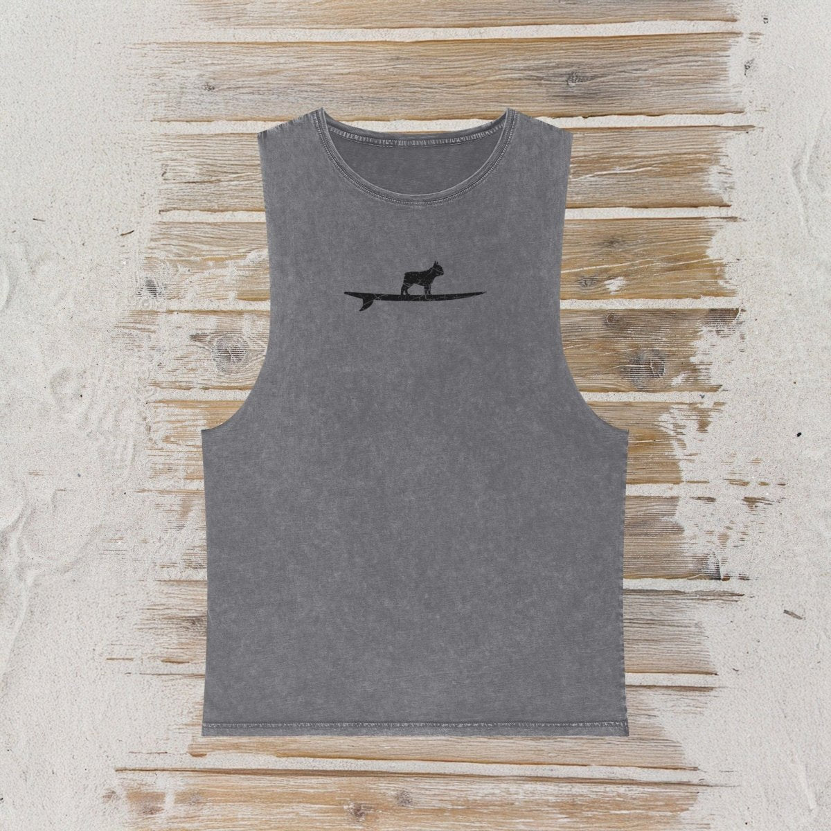 A gray sleeveless tank top with a small black graphic of a frenchy bulldog standing on a surfboard on the chest, displayed flat against a rustic wood  background.