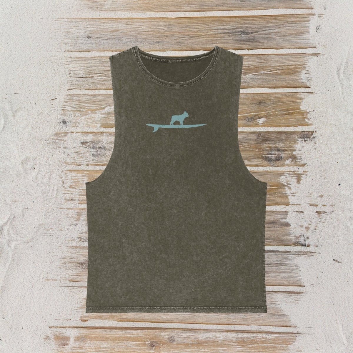 An olive green sleeveless tank top with a light grey graphic of a dog standing on a surfboard on the chest, displayed flat on a rustic wood plank background.