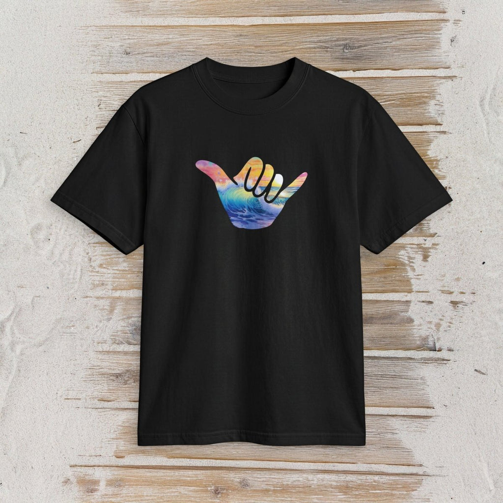 A black short-sleeve crewneck t-shirt featuring a colorful Hawaiian 'shaka' sign graphic on the chest, displayed flat against a rustic light wood plank background.