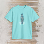 A light aqua blue short-sleeve t-shirt laid flat on a rustic light wood background. The center of the shirt features a graphic of a dark blue surfboard with white text reading 'Wait for Surfing to Be My Future' and white floral designs on either side.