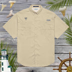 Beige short-sleeve shirt with shark tooth embroidery on a wooden background with decorative nautical elements.