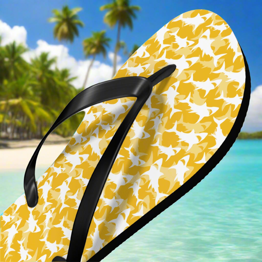 Yellow flip-flop with black strap on a beach background