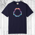 A navy blue short-sleeve t-shirt with a colorful graphic of an open shark mouth on the chest, displayed flat against a white wood plank background.