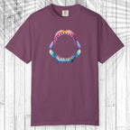 A short-sleeve crewneck t-shirt in a dusty plum purple color, featuring a colorful graphic of a shark's open mouth with sharp teeth on the chest. The shirt is displayed flat against a white wood plank background.