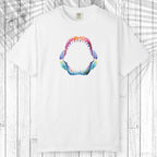 A white short-sleeve crewneck t-shirt featuring a colorful graphic of an open shark mouth with sharp teeth, displayed flat against a white wood plank background with a palm leaf overlay.