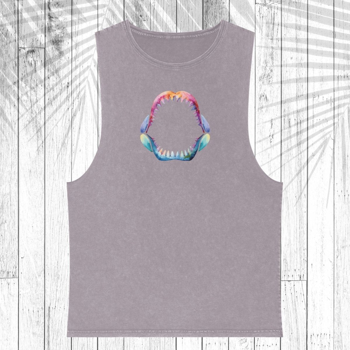 A sleeveless heather gray tank top featuring a colorful graphic of a wide-open mouth with sharp teeth in the center chest, displayed on a white wood plank background with a palm leaf overlay.