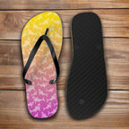 Flip-flop with colorful shark pattern and black insole on a rustic nautical wood background
