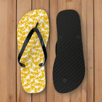 Flip-flop with yellow shark pattern and black strap on the deck of a vintage sailboat moored to a pier in the virgin islands