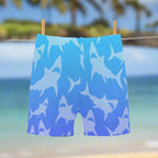Blue swim shorts with shark pattern hanging on a clothesline near the ocean in Maui
