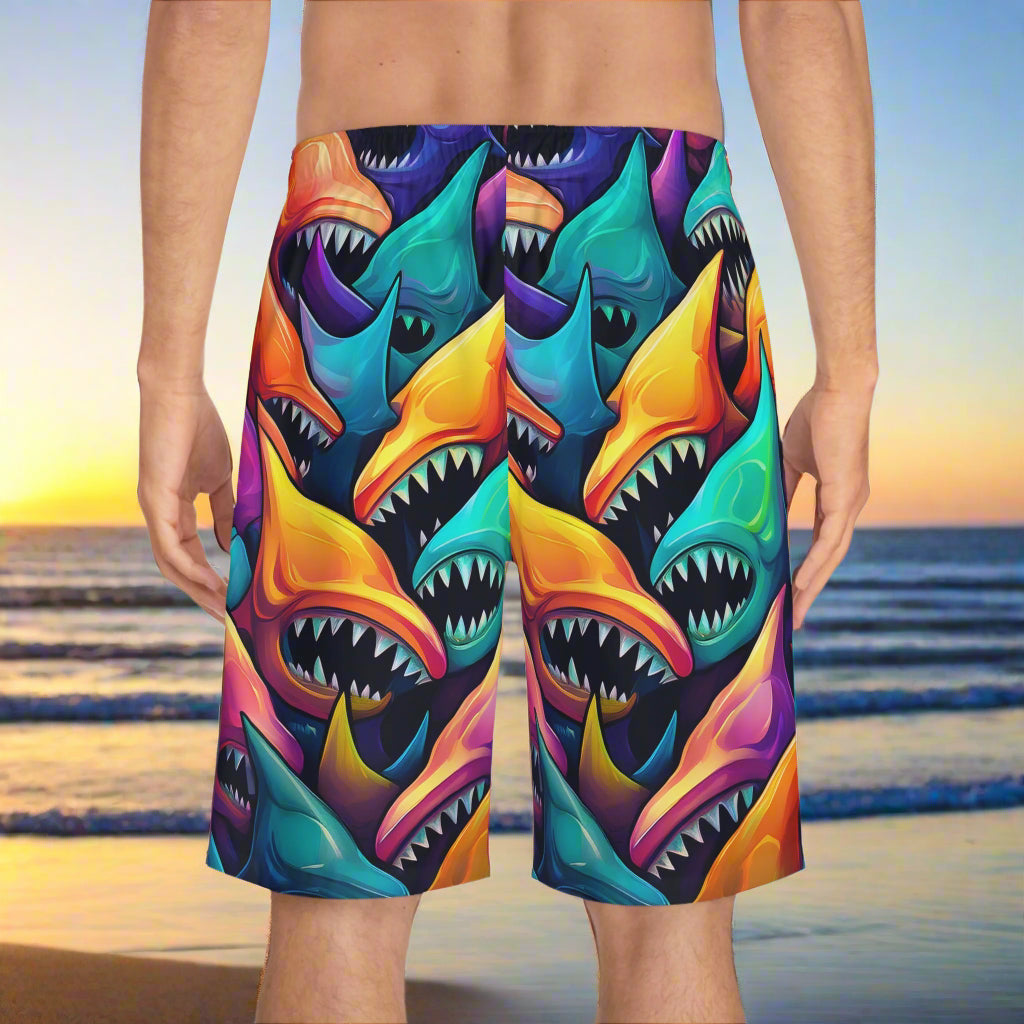 vibrant surreal shark pattern board shorts on surfer looking out over the sea at sunrise