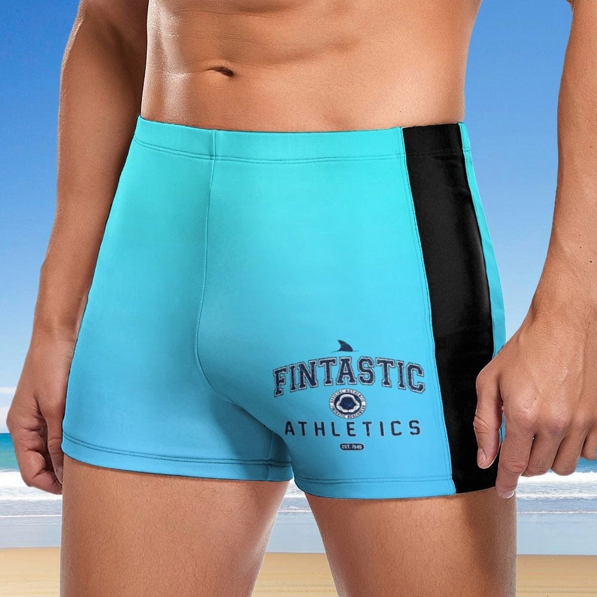 Blue athletic shorts with black side panel and 'FINTASTIC ATHLETICS' text against a beach background.