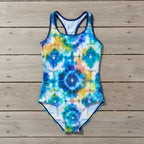Multicolored tie-dye swimsuit on a nautical wood deck