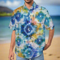 Guy wearing a colorful shibori style tie-dye shirt standing alone on a beach in Maui.