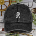 Black cap with skull and crossbones design on a wooden background with vintage elements.