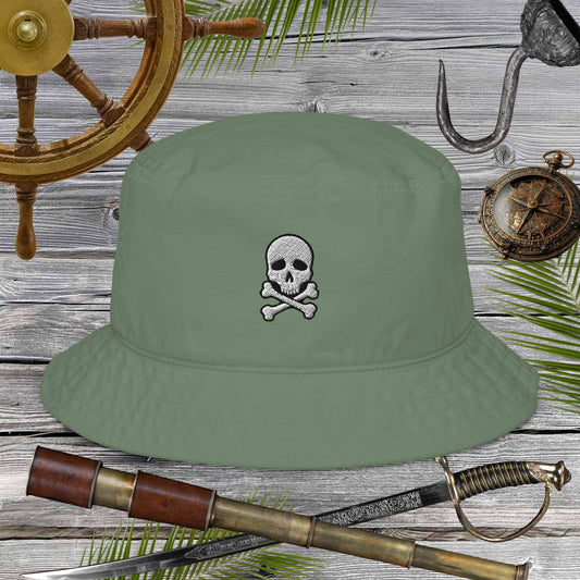 Green bucket hat with skull and crossbones design on a wooden background with pirate-themed items.