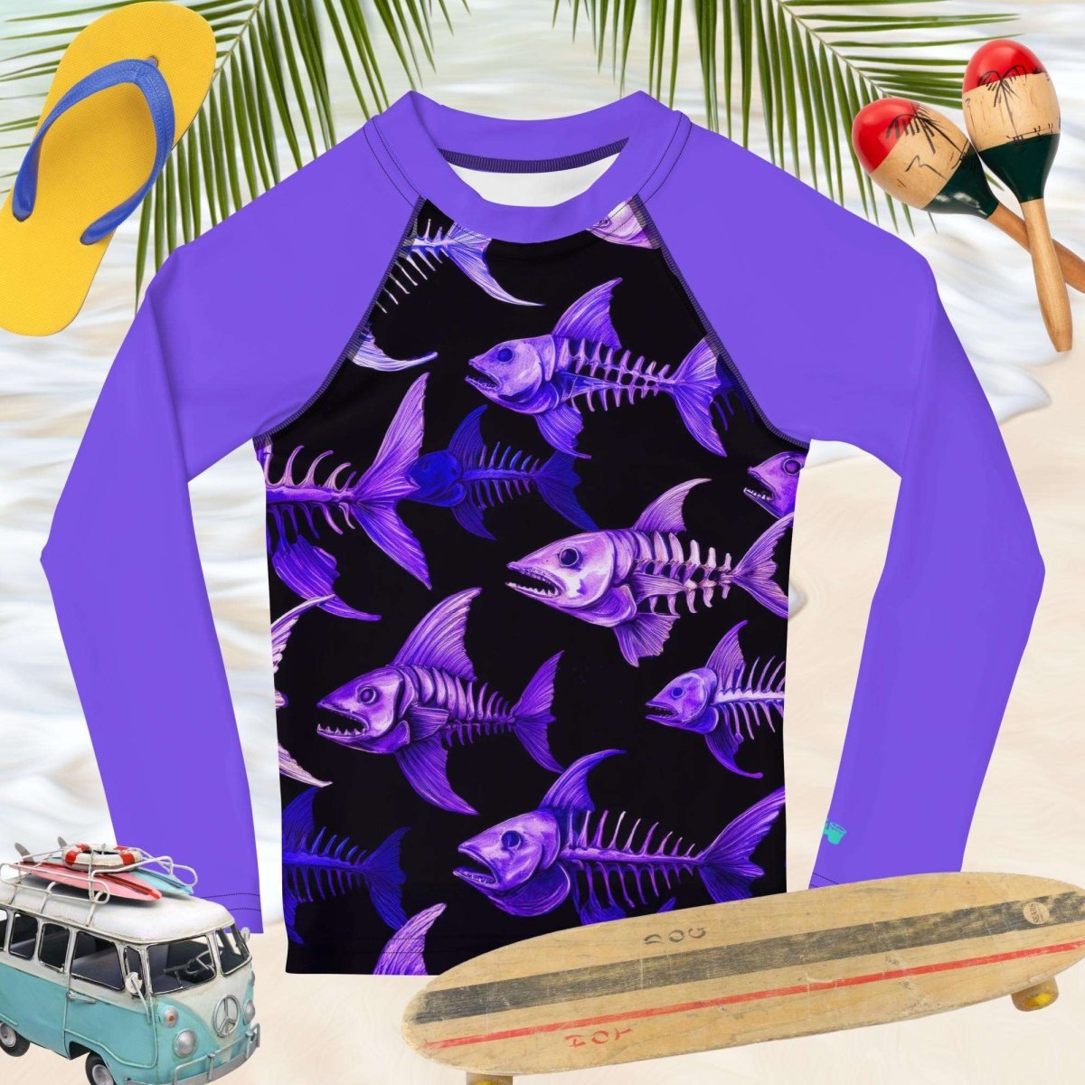 Purple long-sleeve sun rashie shirt with fish skeleton pattern on a beach-themed background