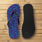 Purple flip-flop with teal dolphin pattern and black insole on a nautical wood background