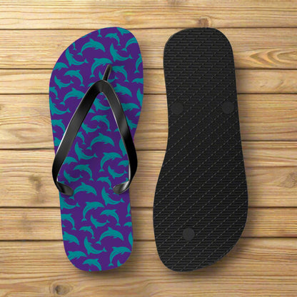 Purple flip-flop with teal dolphin pattern and black insole on a nautical wood background
