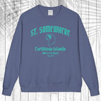 A slate blue crewneck sweatshirt with a teal graphic print reading 'ST. SOMEWHERE Caribbean Islands' and 'Where It's Warm Since 1996' on the front, displayed flat against a white wood plank background.