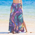 Person wearing a colorful stained glass patterned sarong wrap on a beach.