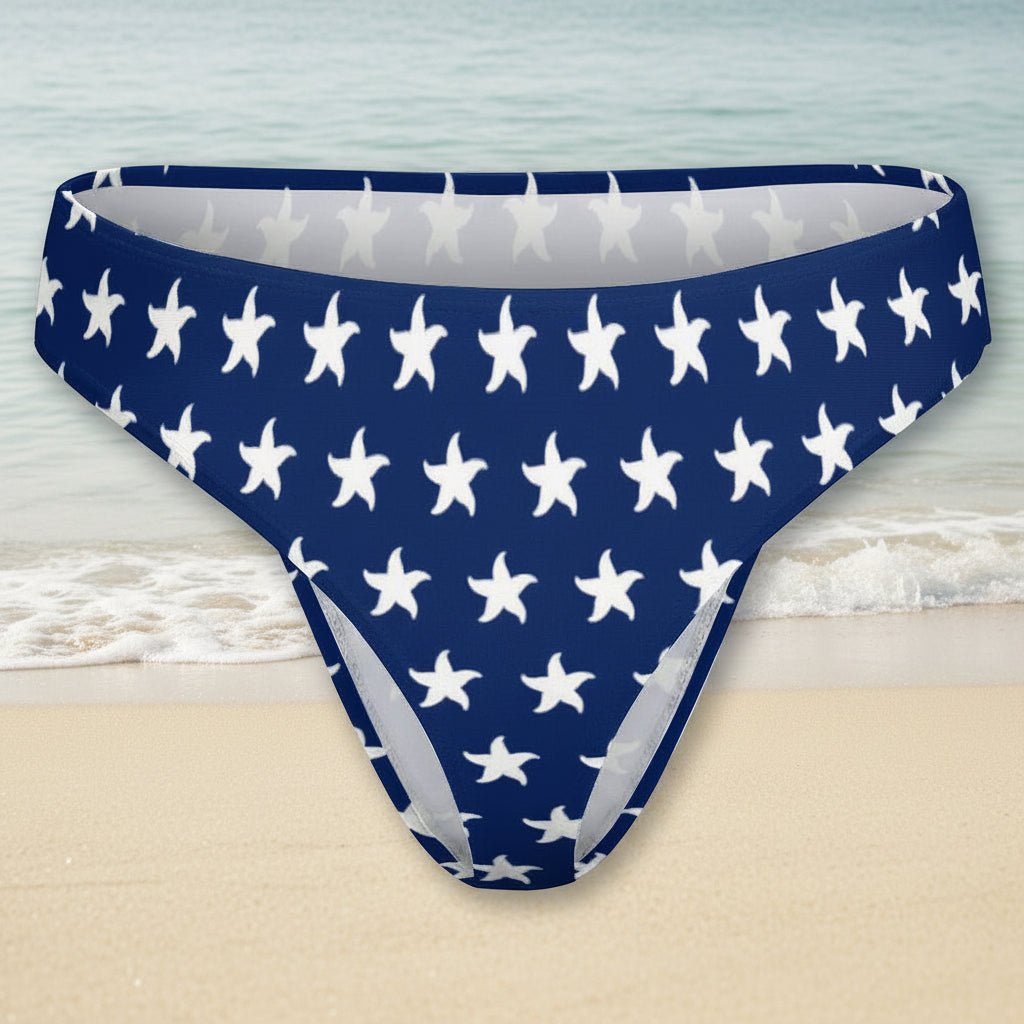 Blue bikini bottom with white starfish pattern on a faded beach background