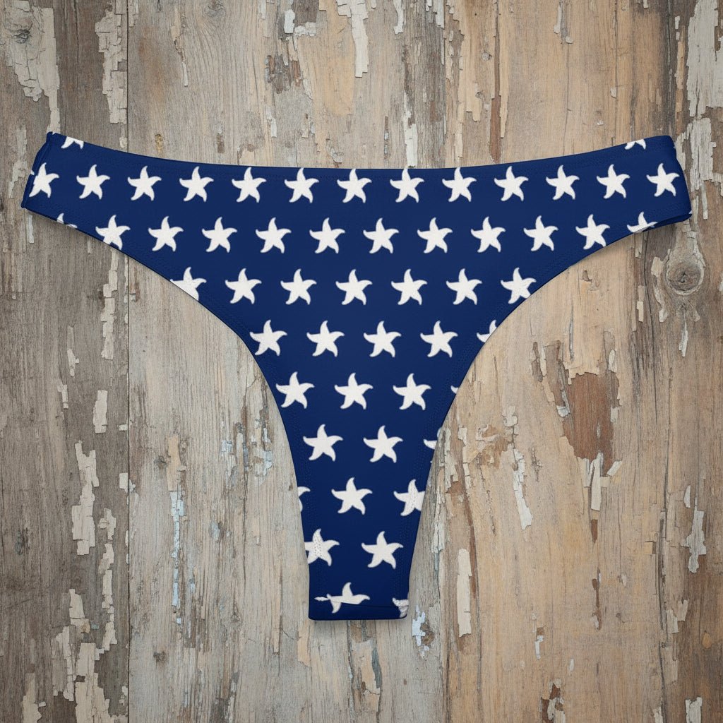 Blue bikini bottom with white starfish pattern on a rustic wood background