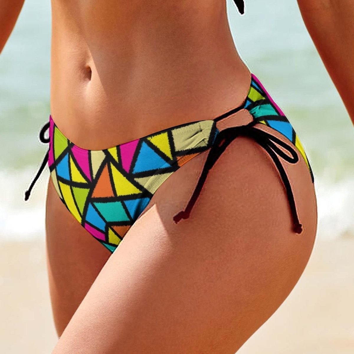 Colorful Pop Art-patterned bikini bottom on a blurred beach background