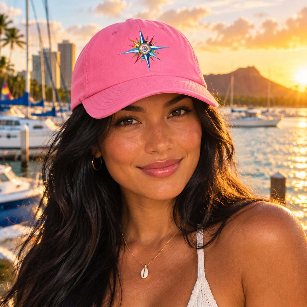 Pink cap with a colorful compass design on a beautiful woman standing a marina in Honolulu