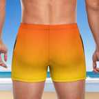 Guy wearing a yellow to orange gradient swim short with a beach background