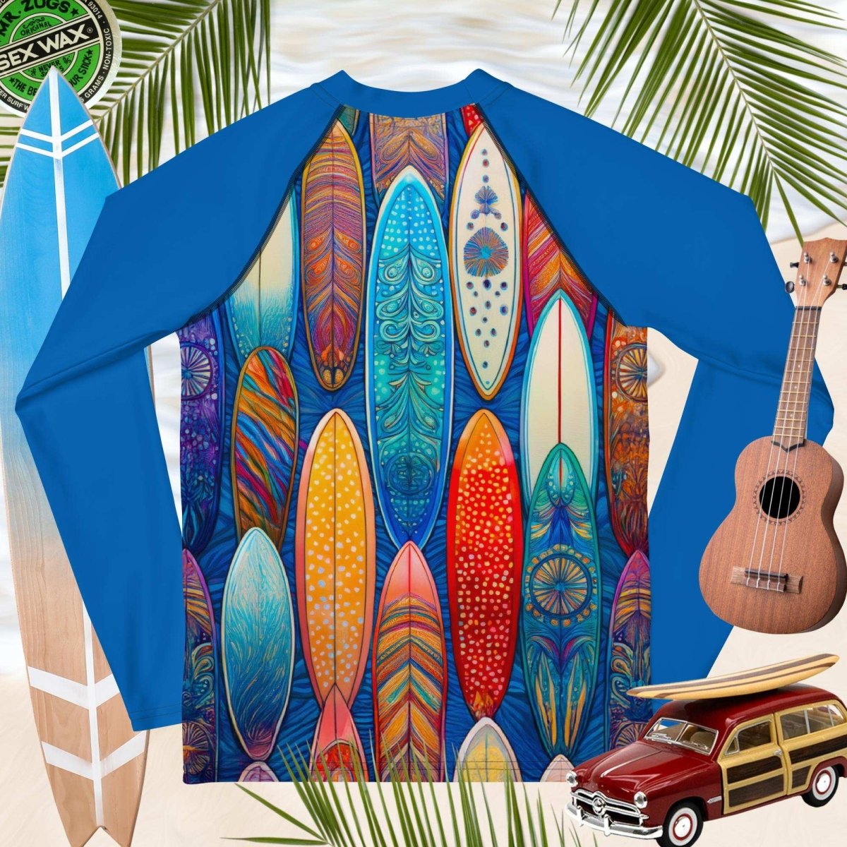 Blue rash guard with colorful surfboard design, surrounded by surfboards, a guitar, and a model woody car.