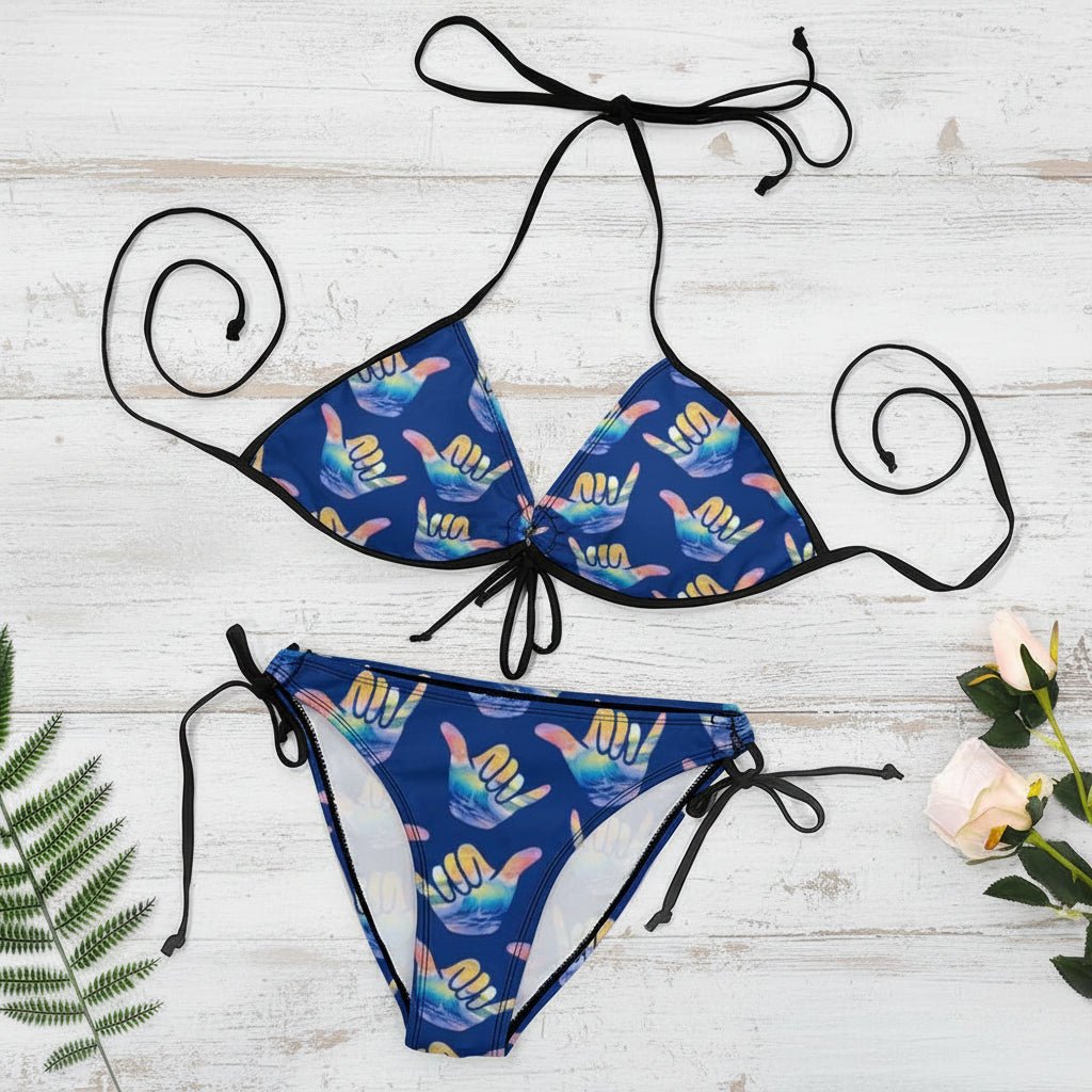 Blue bikini set with colorful hand signs on a white nautical wood background