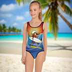 Girl's One Piece Swimsuit featuring cool surfer woman art worn by girl standing on a beach in paradise
