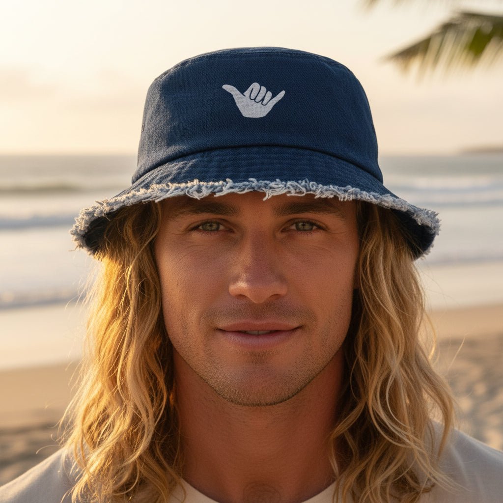 Navy blue bucket hat with a white shaka logo on surfer in La Jolla