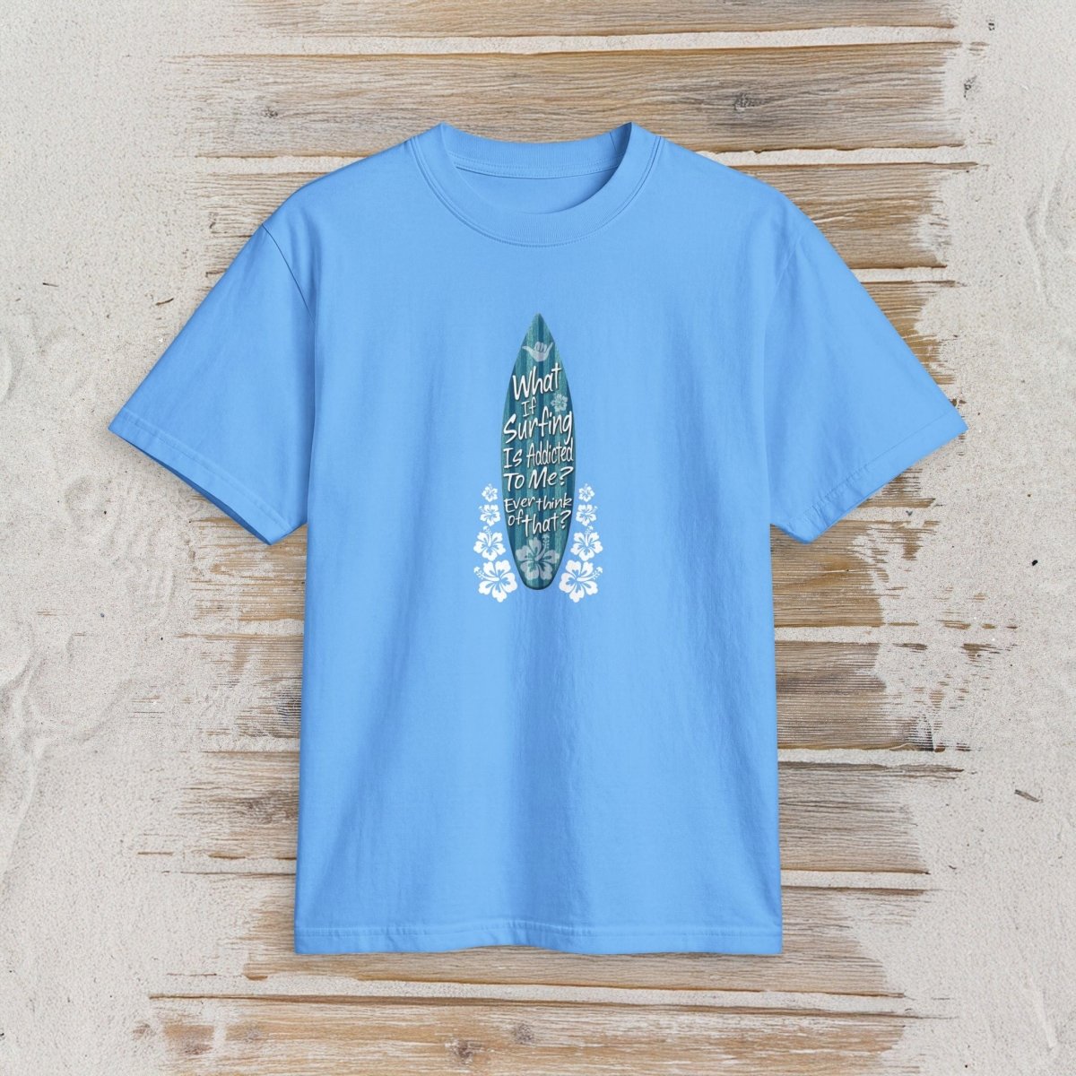 A blue short-sleeve crewneck t-shirt featuring a vertical blue surfboard graphic with the text 'My World Is Surfing To Me' on a rustic, whitewashed wooden background.