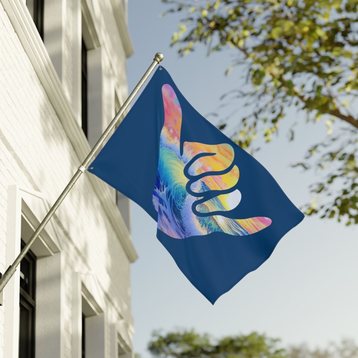 Colorful hand design flag on a building with trees in the background