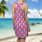 Swimwear model walks the beach on fashion island and the tide rolls out. she's looking for seashells in her swimsuit cover up with seahorse pattern