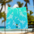Turquoise swim shorts with shark pattern on a hanging on a line in Kailua Beach