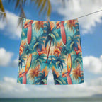Tropical-themed swim trunks with palm trees and surfboards pattern hanging on a clothesline in a tropical surfers paradise