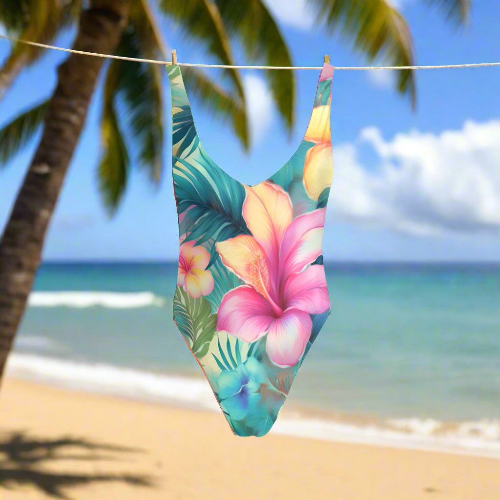 One-piece swimsuit with tropical floral design hanging on a line outside a beachside tiki hut in Maui