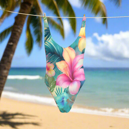 One-piece swimsuit with tropical floral design hanging on a line outside a beachside tiki hut in Maui