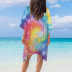Bikini Model wearing a colorful tie-dye cover-up looking out over the water on Miami Beach with clear blue water and sky.