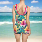1 piece swimming suit with a retro vibe on young swimwear model watching the waves as the tide comes in.