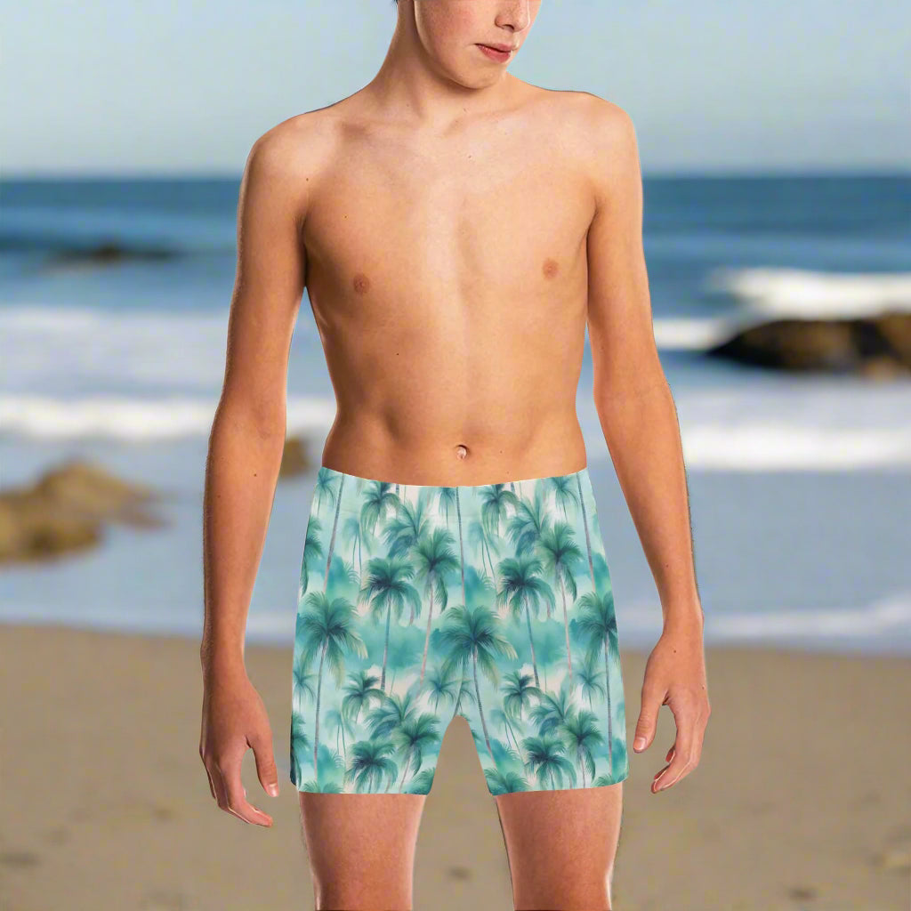 young dude wearing palm tree patterned swim shorts on a beach in La Jolla