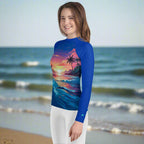 Teen wearing rash guard with Island Lagoon design standing on Daytona Beach