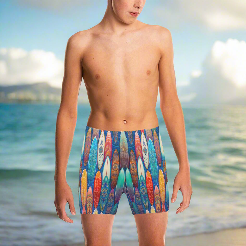Teen Dude wearing colorful surfboard patterned swim shorts on Waikiki Beach