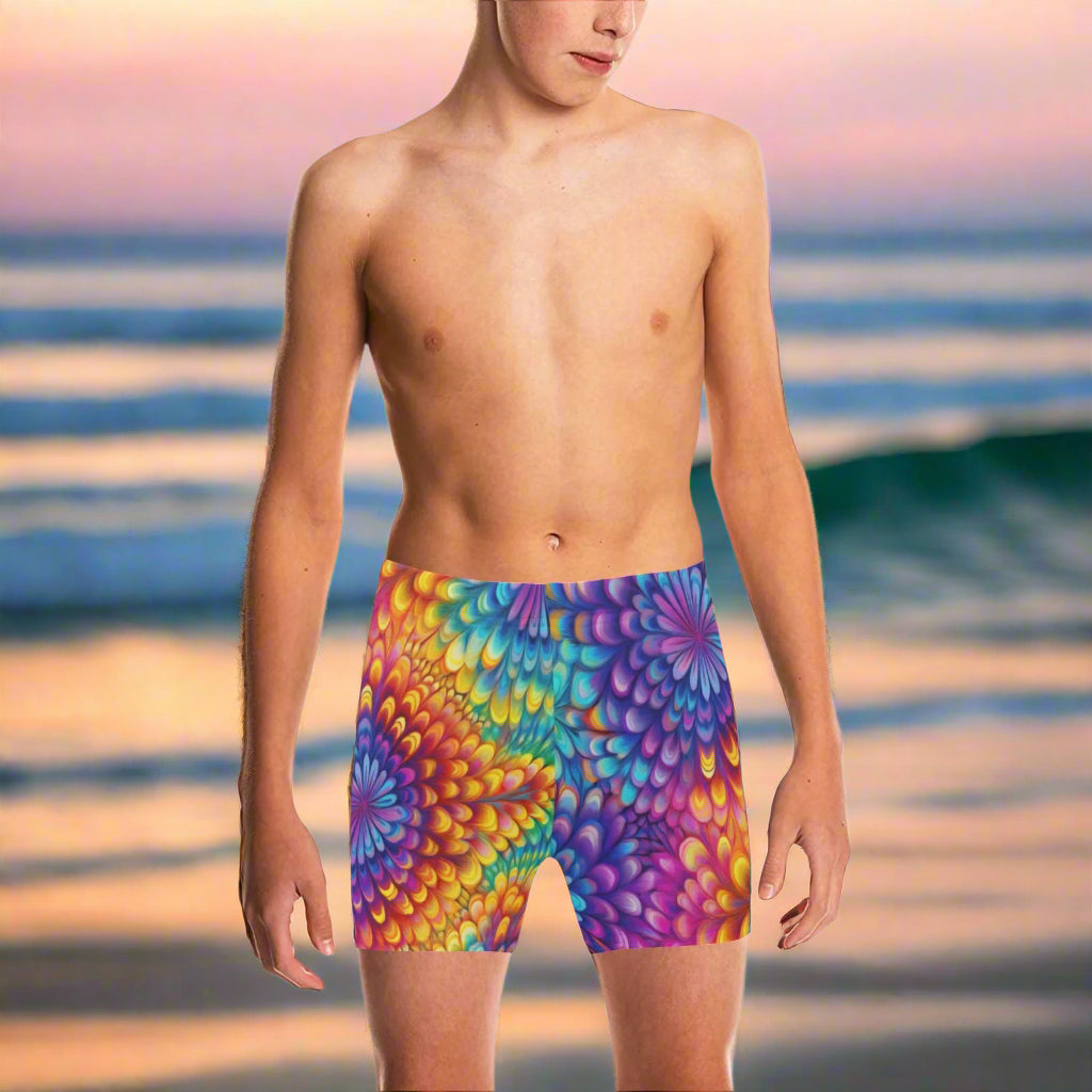 Teen Dude wearing colorful swim shorts on a California beach at sunset