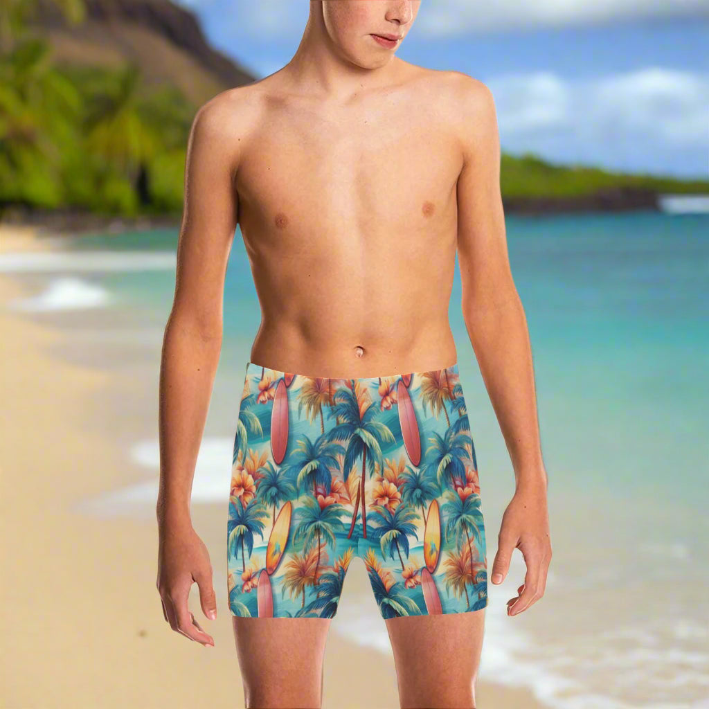 Young dude wearing tropical-surf themed swim shorts hanging loose on a Hawaiian Island beach