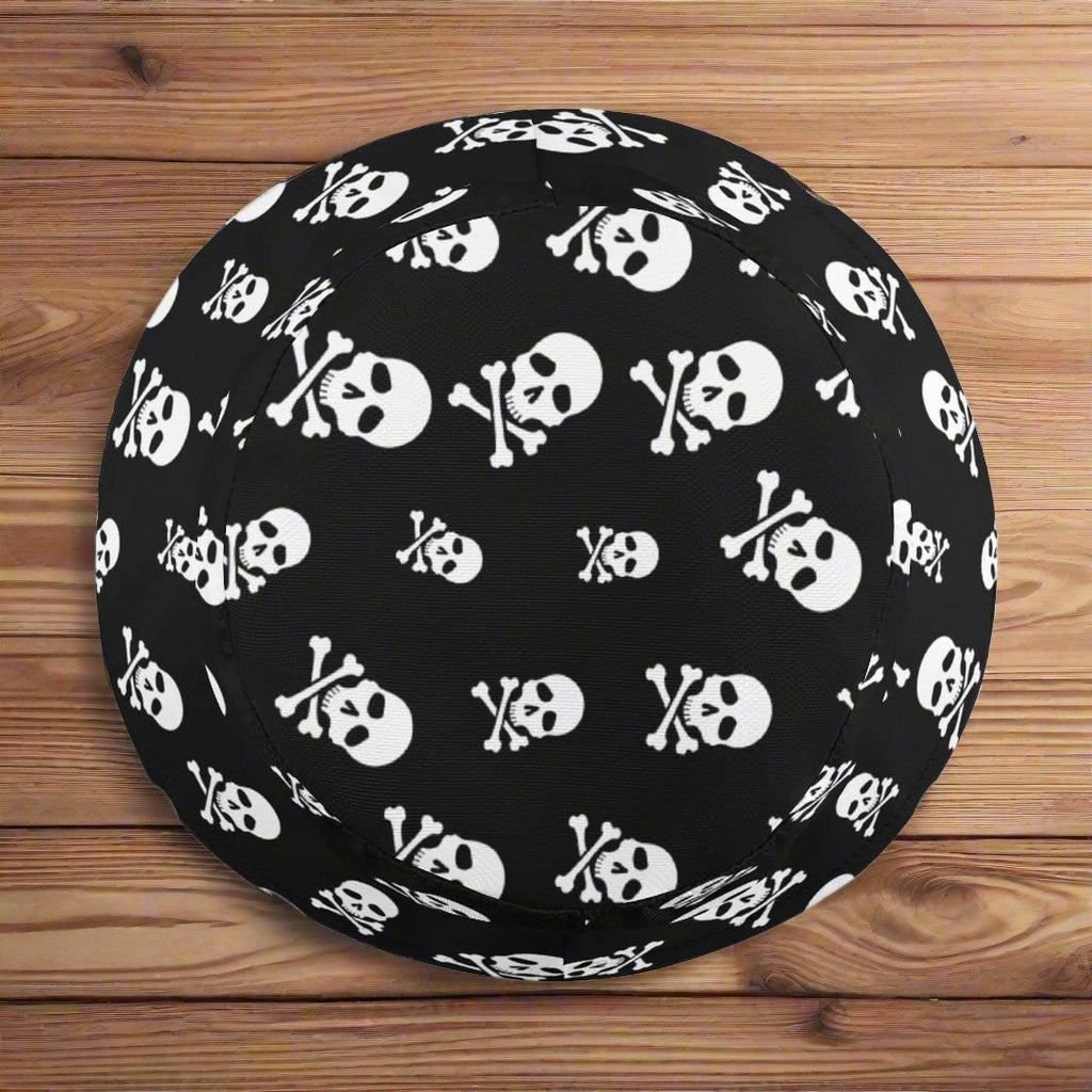 Black bucket hat with white skull and crossbones pattern on a nautical wood background