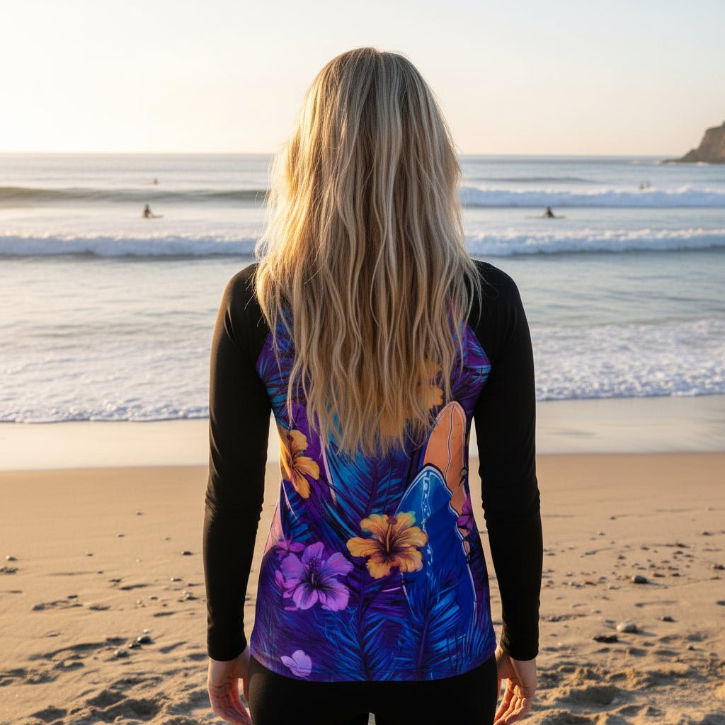 Person wearing a colorful hibiscus floral sun rashie, watching surfers from the La Jolla Cove Beach 
